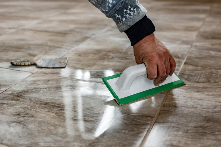 Unlocking Radiance: A Comprehensive Guide to Successful Travertine Honing and Polishing - grouting-travertine-tiles-tilers-filling-space-tiles-using-rubber-trowel
