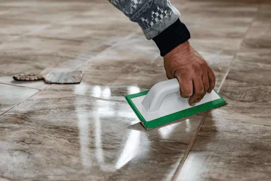 Unlocking Radiance: A Comprehensive Guide to Successful Travertine Honing and Polishing - grouting-travertine-tiles-tilers-filling-space-tiles-using-rubber-trowel