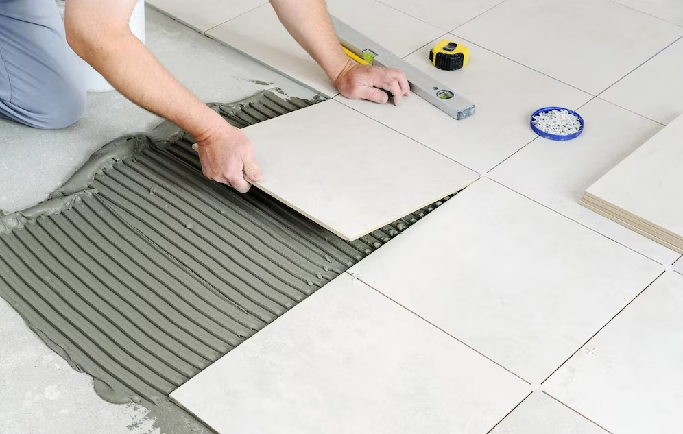 hands-worker-are-laying-ceramic-tile-floor_191163-2069