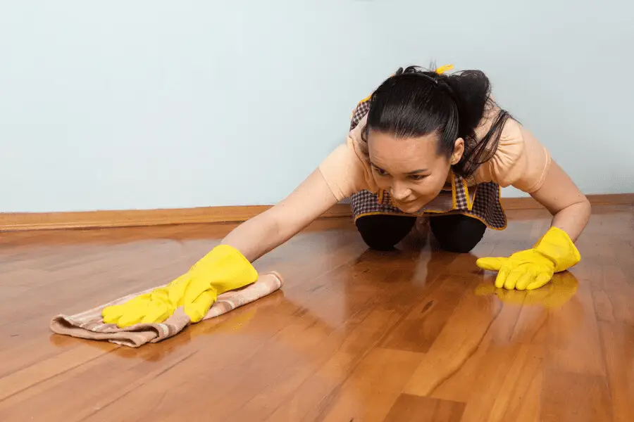 Floor Makeover 101: A Deep Dive into Stripping and Waxing - young-housewife-with-yellow-gloves-cleaning-floor